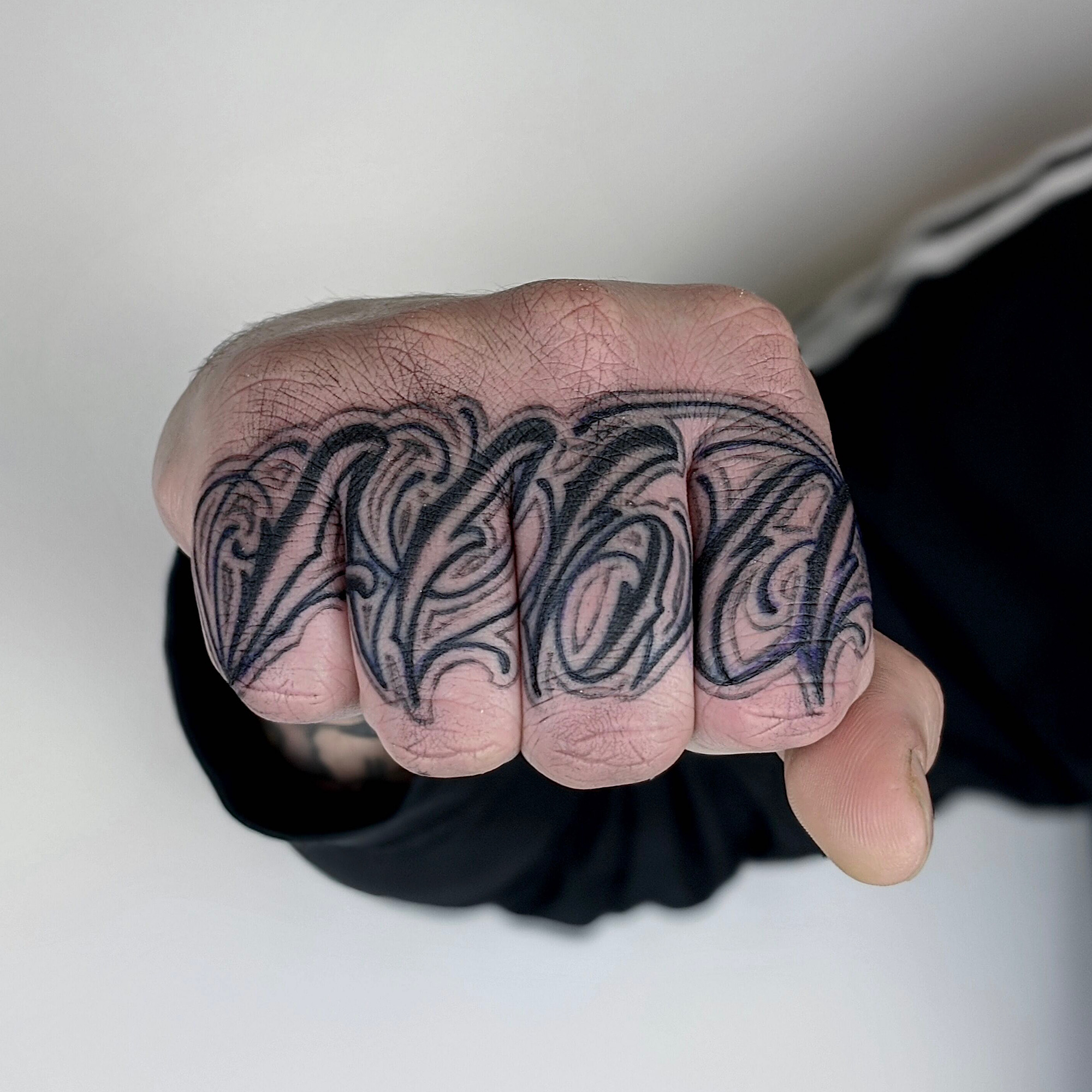 script tattoo across fingers love letters black and grey gray lettering hand tattoo by Rick Ricardo Pedro at Nexus Collective