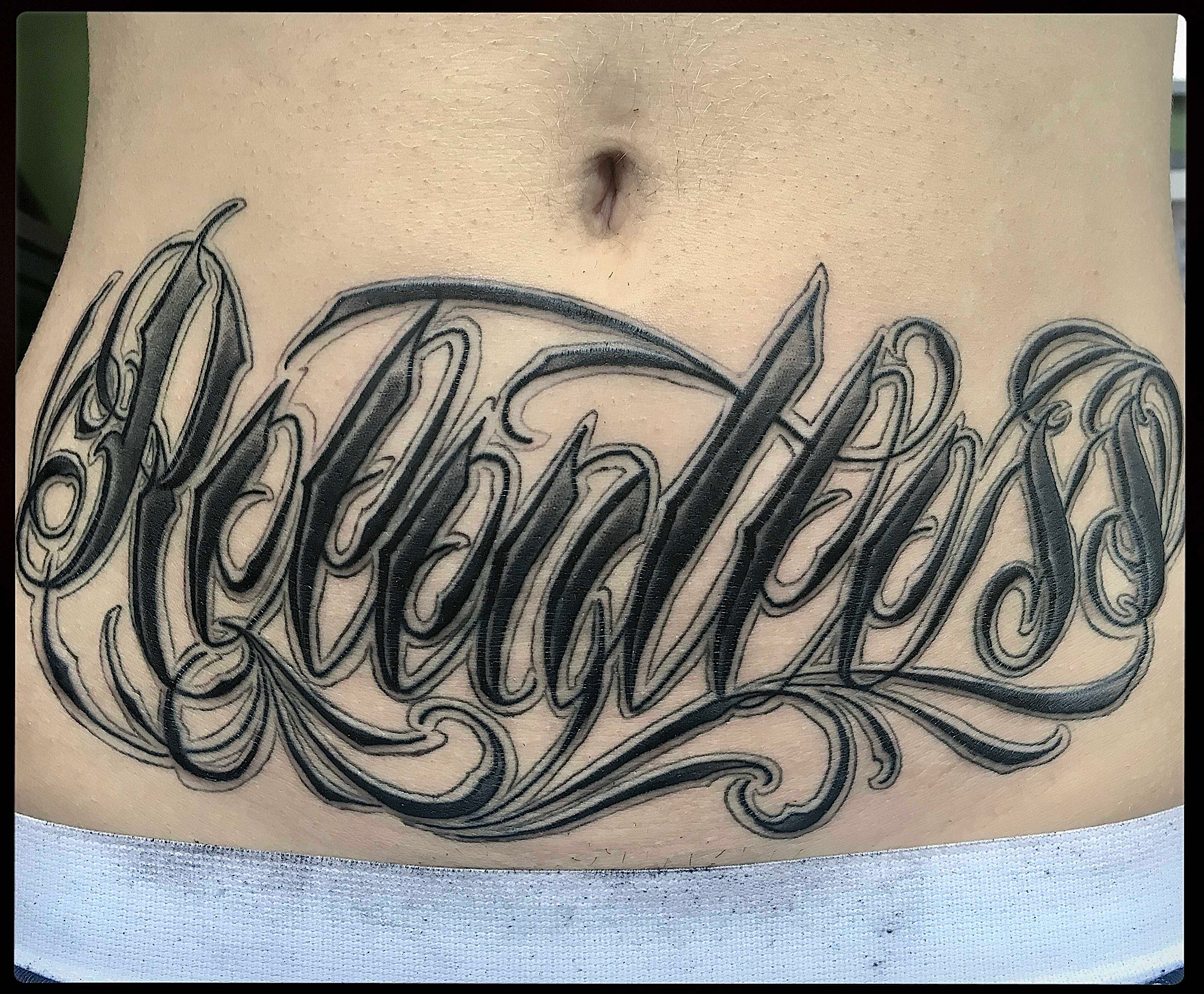 relentless script stomach tattoo love letters black and grey gray lettering tattoo love letters by Ricks custom tattooing Ricardo Pedro at Nexus Collective